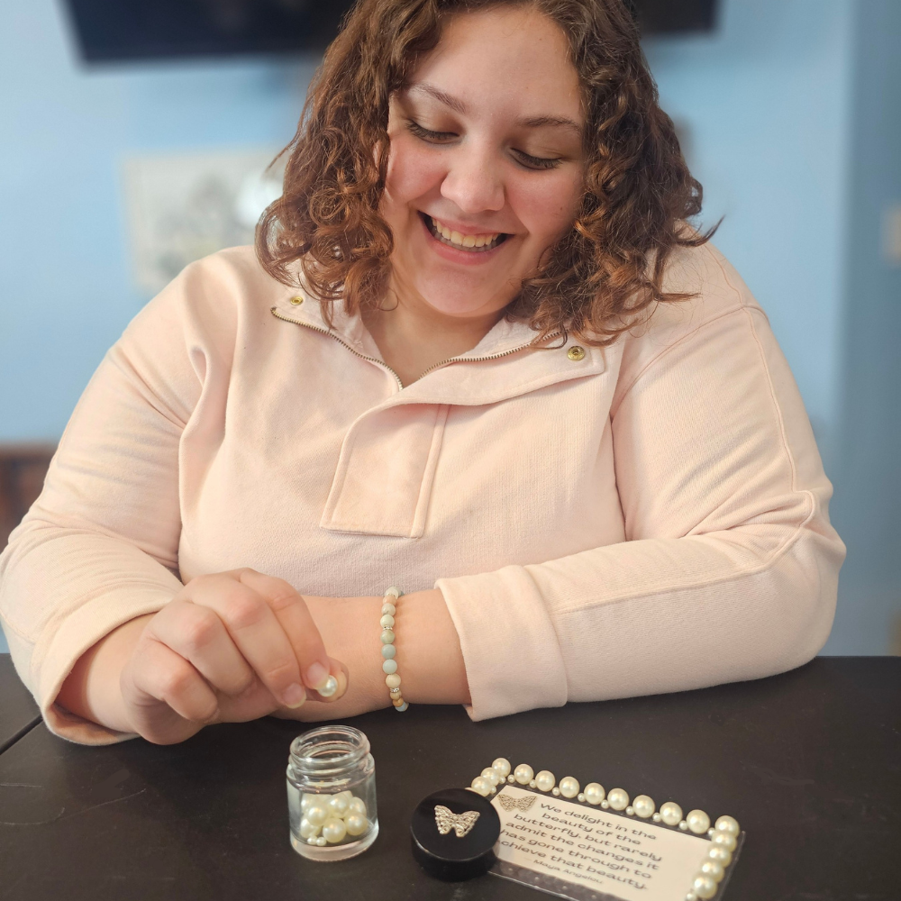 woman putting a bead in a jar